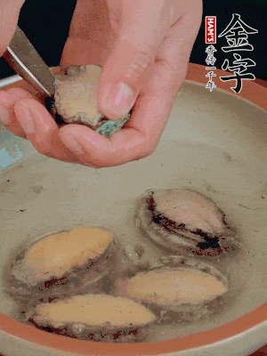 鮑魚加鹽、清水浸泡，用勺子挖出鮑魚肉。