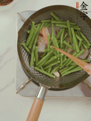下掰好的缸豆段翻炒，略燜煮。