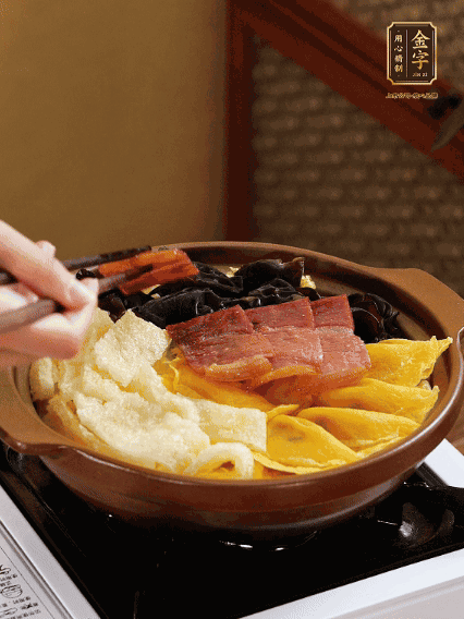 砂鍋底部鋪上娃娃菜，依次擺上肉皮、蛋餃、黑木耳、火腿